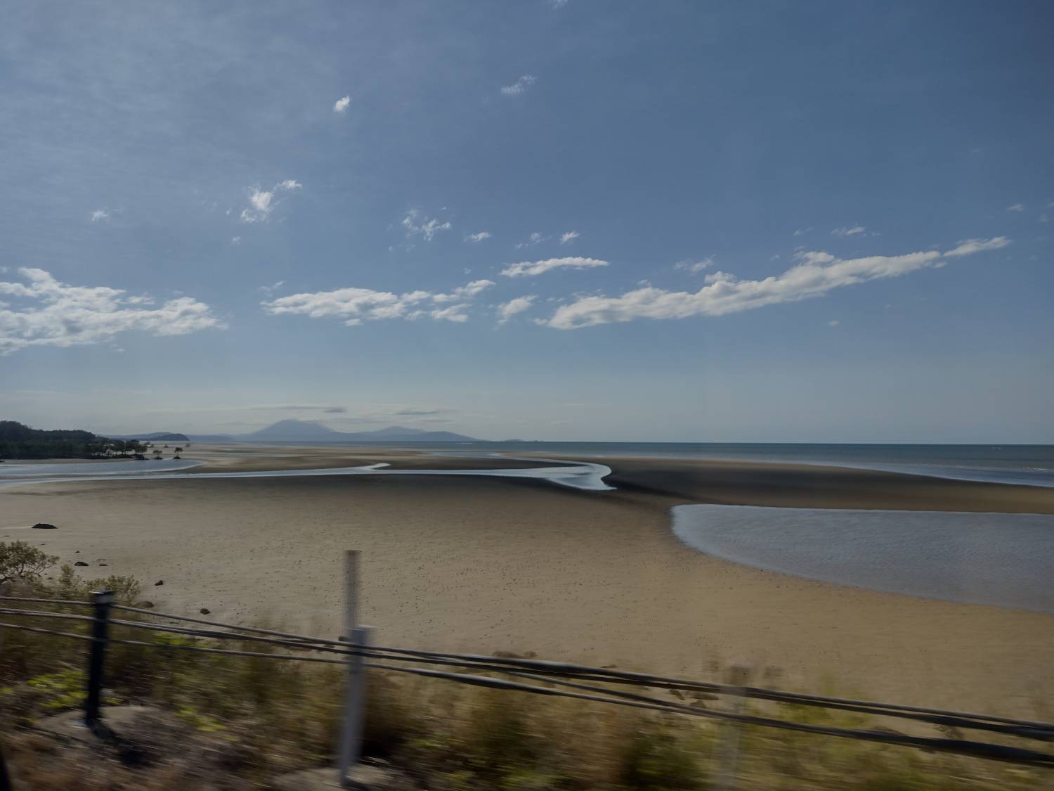 A flat beach with puddles of water